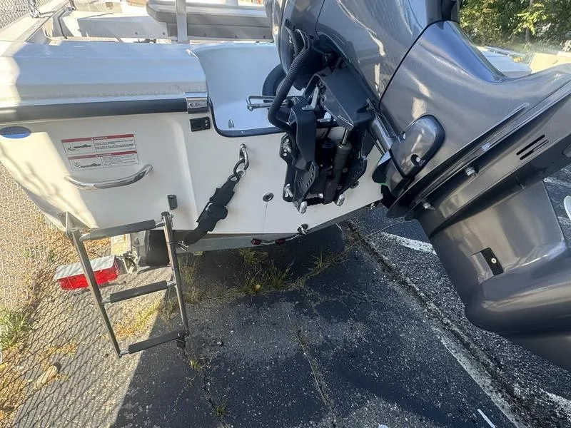 Slide: The Image of 2024 Edgewater 158CS boat with outboard motor and ladder on asphalt surface. - 11