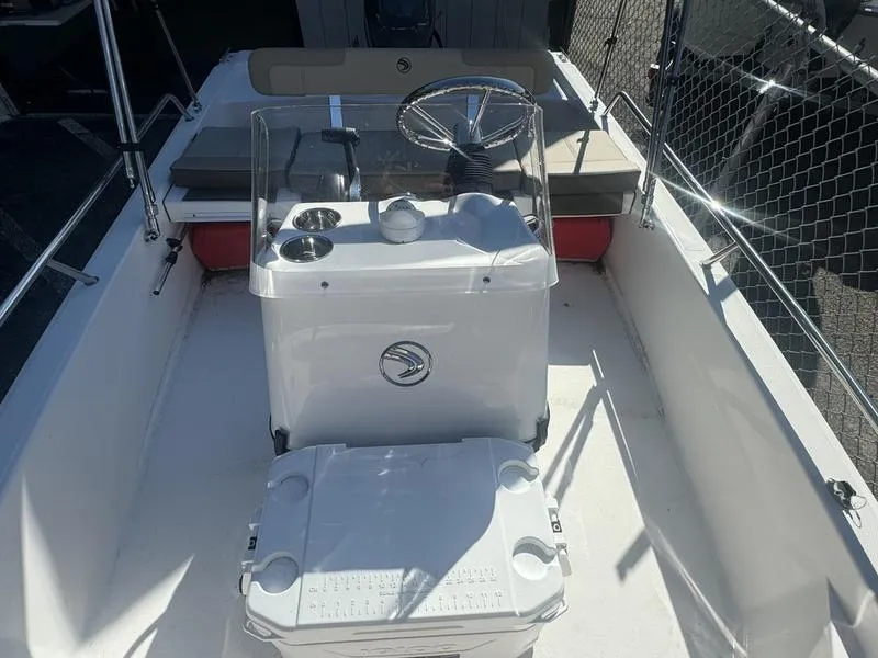 Slide: The Image of 2024 Edgewater 158CS boat interior with steering console and seating. - 6