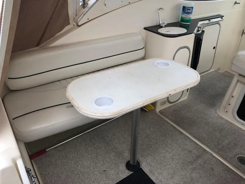 Slide: The Image of 2002 Maxum 3300 SCR boat interior with seating, table, and sink. - 11