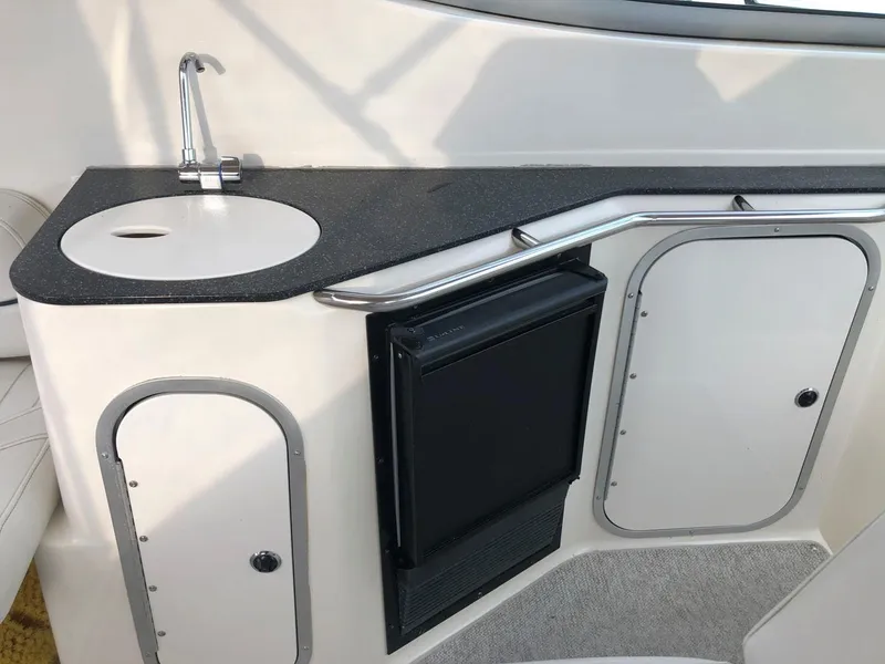 Slide: The Image of 2002 Maxum 3300 SCR boat kitchenette with sink, countertop, and storage cabinets. - 14