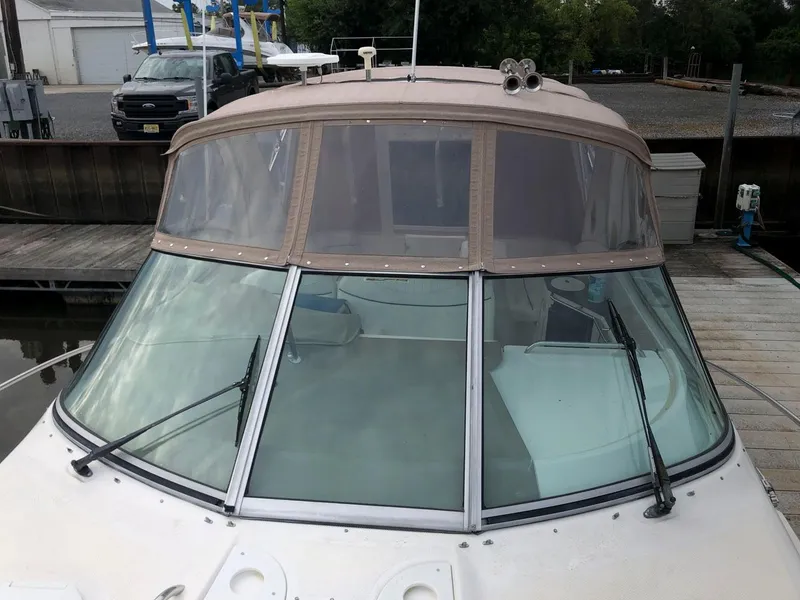 Slide: The Image of 2002 Maxum 3300 SCR boat docked, front view with windshield and canvas cover. - 4