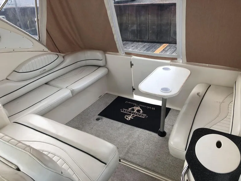 Slide: The Image of 2002 Maxum 3300 SCR boat interior with white leather seating and small table. - 5