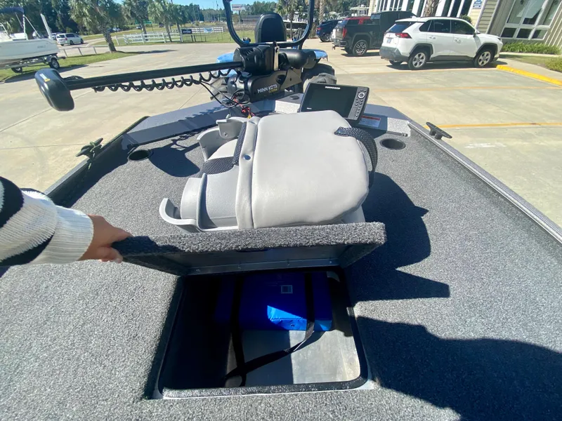 Slide: The Image of 2023 Crestliner 1600 Storm boat with open storage compartment and fishing equipment. - 12