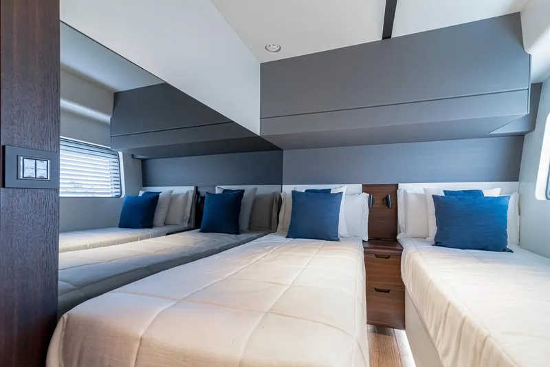 Slide: The Image of 2024 Astondoa AS5 yacht twin bedroom with modern decor and blue accent pillows. - 19