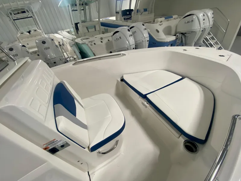 Slide: The Image of 2024 Robalo R180 Center Console boat interior with white and blue seating. - 12