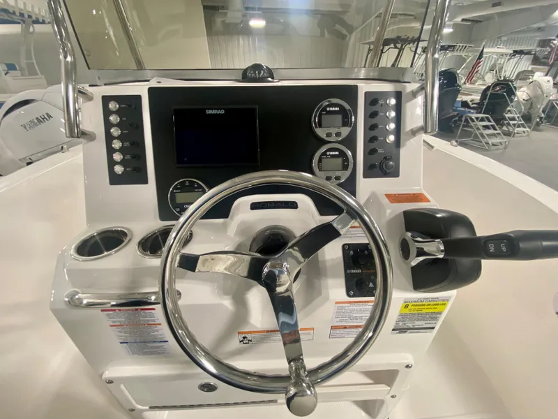 Slide: The Image of 2024 Robalo R180 Center Console boat dashboard with steering wheel and controls. - 9