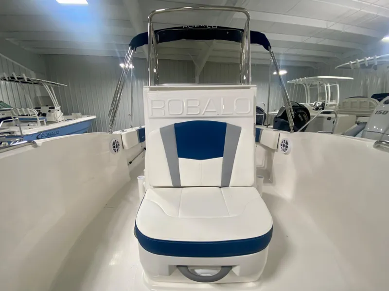 Slide: The Image of 2024 Robalo R180 Center Console boat interior with white and blue seating. - 13
