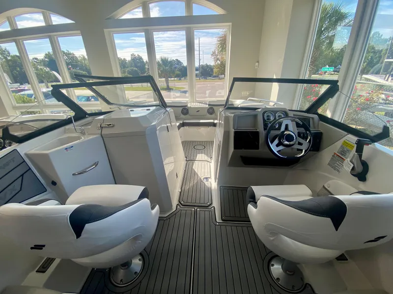 Slide: The Image of 2024 Starcraft SVX 230 OB boat interior with dual captain chairs and modern dashboard. - 11