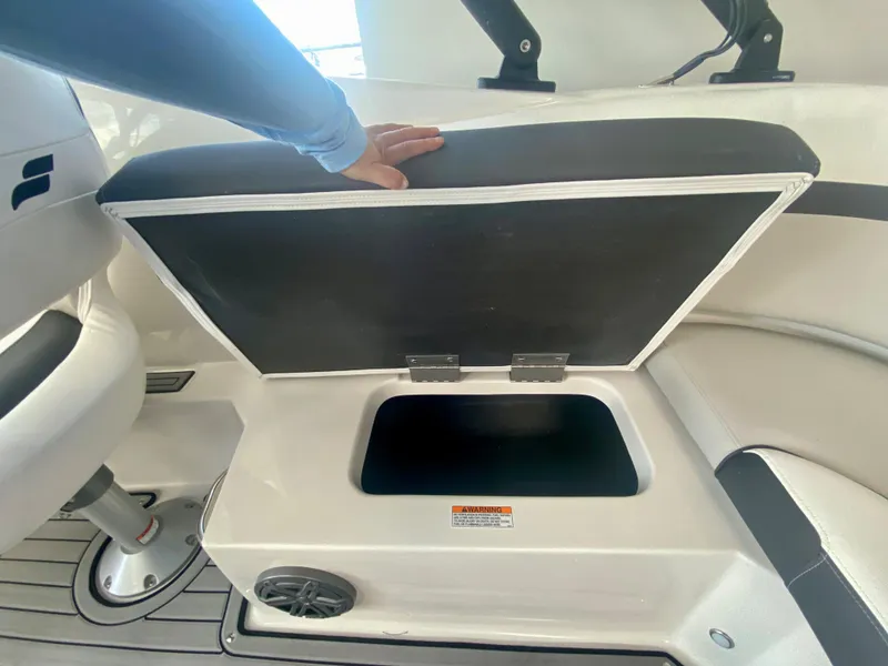 Slide: The Image of 2024 Starcraft SVX 230 OB boat storage compartment with cushioned seat lifted. - 8