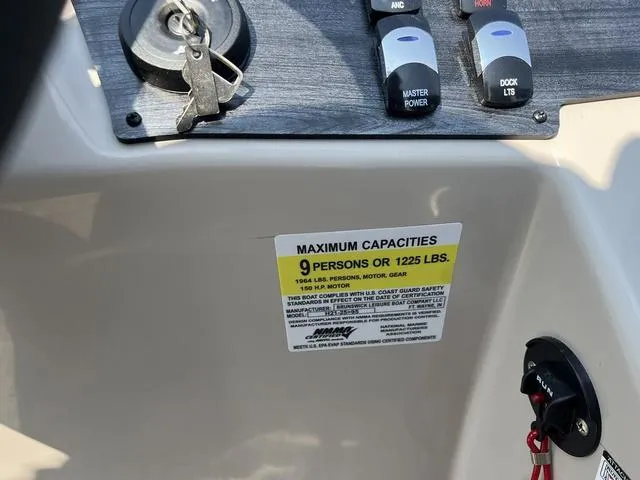 Slide: The Image of 2023 Harris Cruiser 210 CW boat capacity label and control panel. - 12