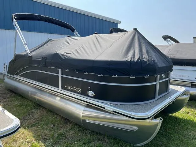 Slide: The Image of 2023 Harris Cruiser 210 CW pontoon boat with black cover, docked on grass. - 5