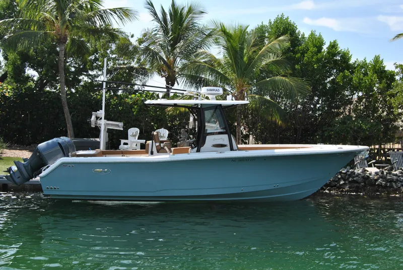 The Image of 2020 Sea Hunt Gamefish 30 boat docked by palm trees, featuring dual engines. - 1