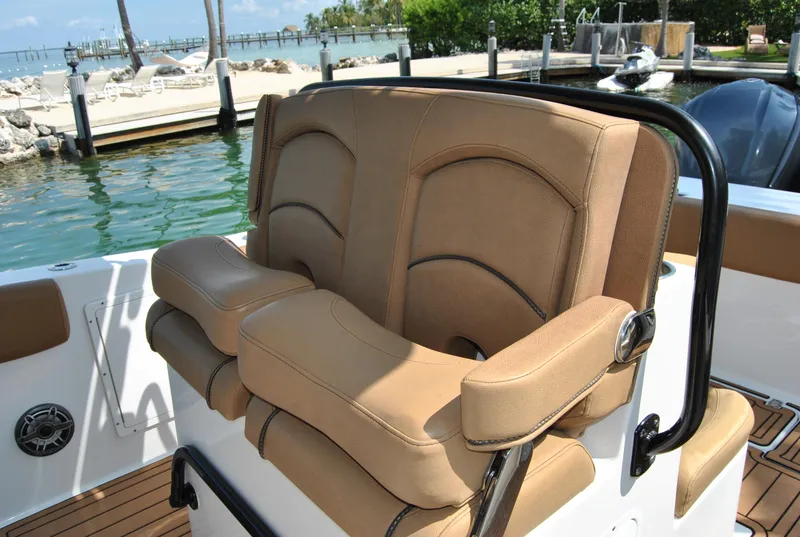 Slide: The Image of 2020 Sea Hunt Gamefish 30 boat seating with tan upholstery, docked by the water. - 14
