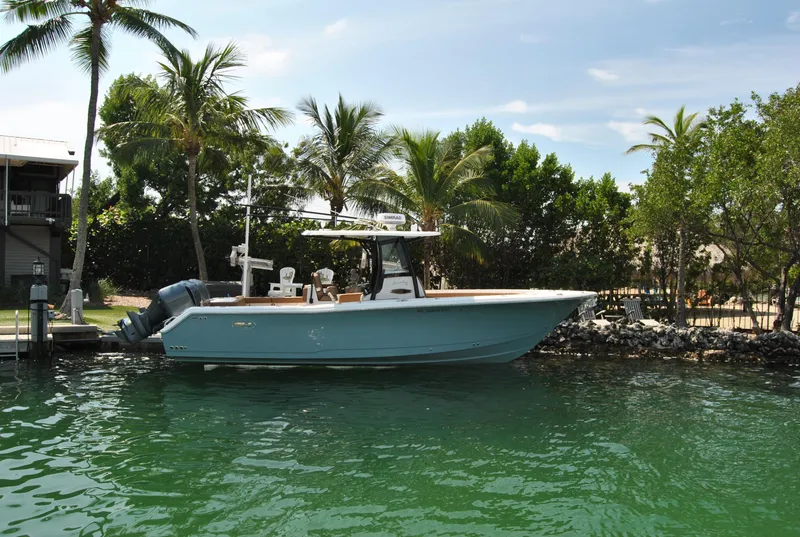 Slide: The Image of 2020 Sea Hunt Gamefish 30 boat docked in tropical waters with palm trees. - 2