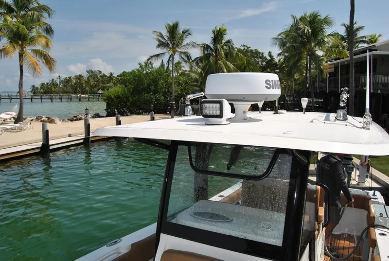 Slide: The Image of Sea Hunt Gamefish 30 boat docked by tropical waterfront, 2020 model. - 20