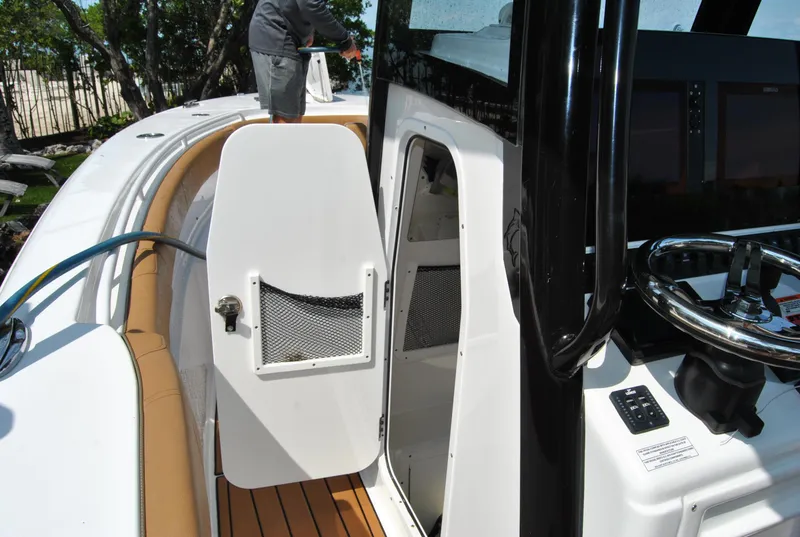 Slide: The Image of 2020 Sea Hunt Gamefish 30 boat interior with open storage compartment and steering console. - 22