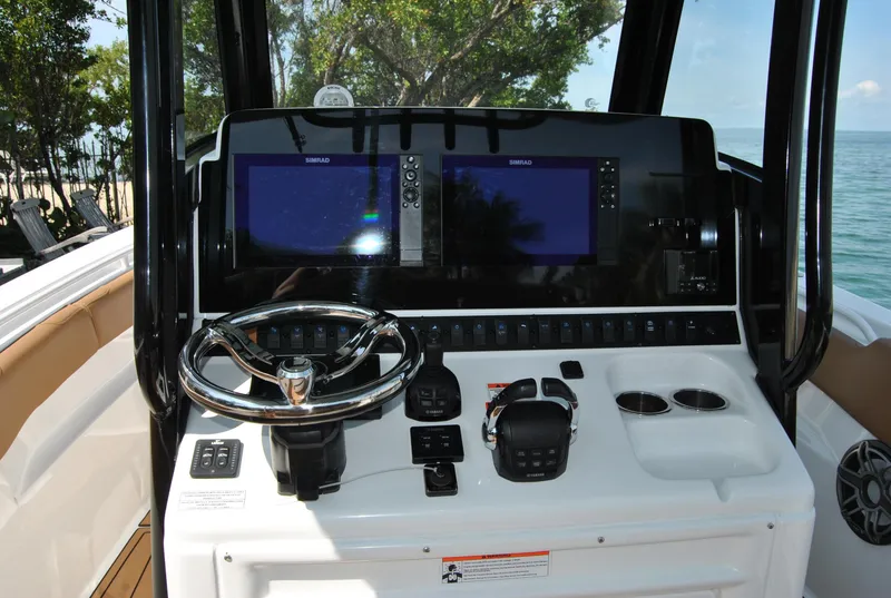Slide: The Image of 2020 Sea Hunt Gamefish 30 boat dashboard with dual screens and steering wheel. - 9