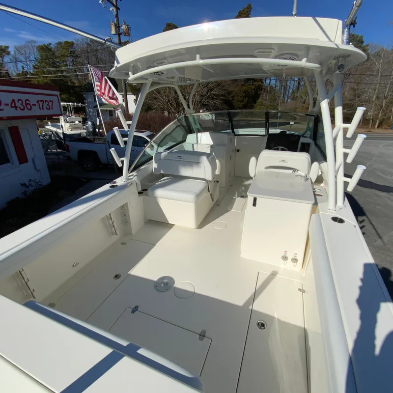 Slide: The Image of 2025 Cobia 280 Dual Console boat with spacious deck and seating area. - 12