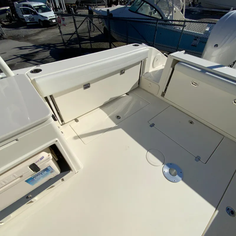 Slide: The Image of 2025 Cobia 280 Dual Console boat interior with storage compartments and seating area. - 14