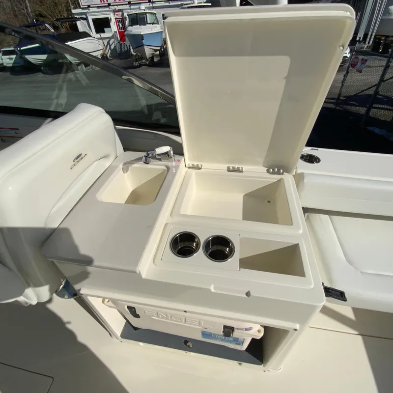 Slide: The Image of 2025 Cobia 280 Dual Console boat with open storage compartment and sink. - 18