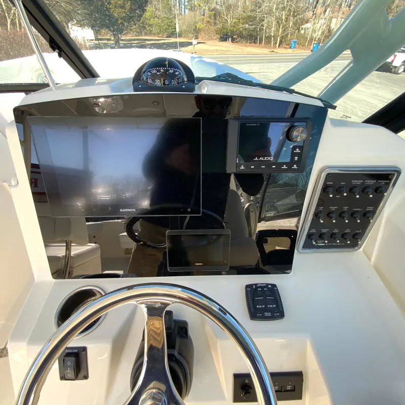Slide: The Image of 2025 Cobia 280 Dual Console dashboard with steering wheel, Garmin display, and control panel. - 20