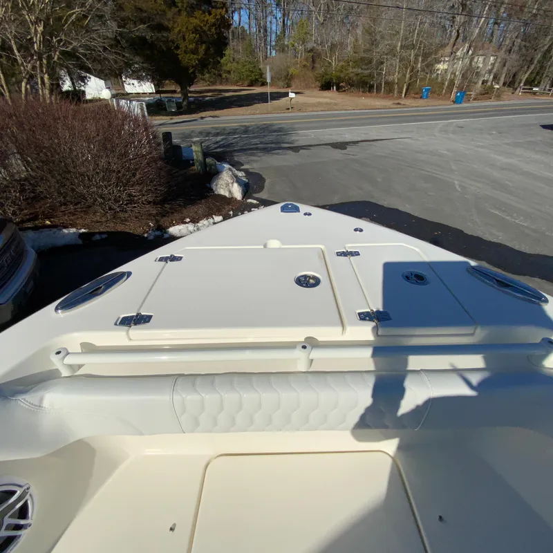 Slide: The Image of 2025 Cobia 280 Dual Console boat bow view, featuring storage compartments. - 30