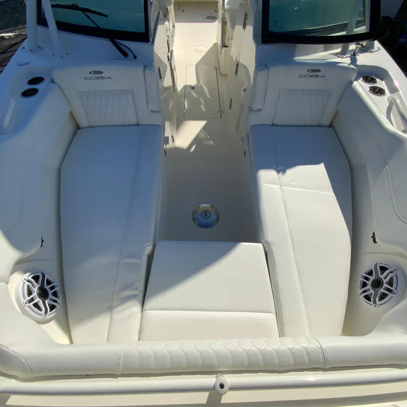 Slide: The Image of 2025 Cobia 280 Dual Console boat interior with white seating and speakers. - 35