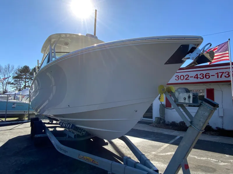 Slide: The Image of 2025 Cobia 280 Dual Console boat on trailer under bright sunlight. - 4