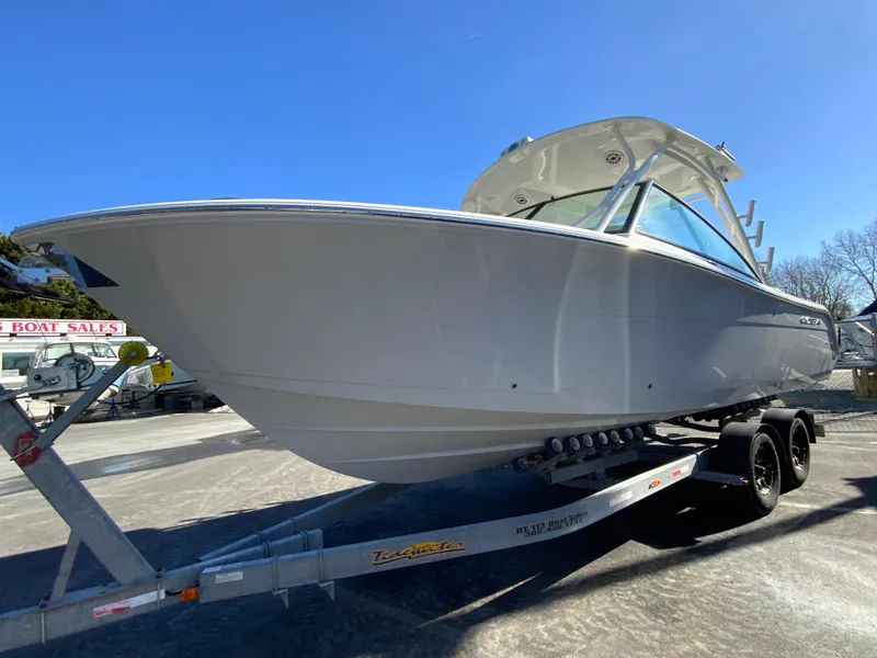 Slide: The Image of 2025 Cobia 280 Dual Console boat on trailer, displayed outdoors. - 6