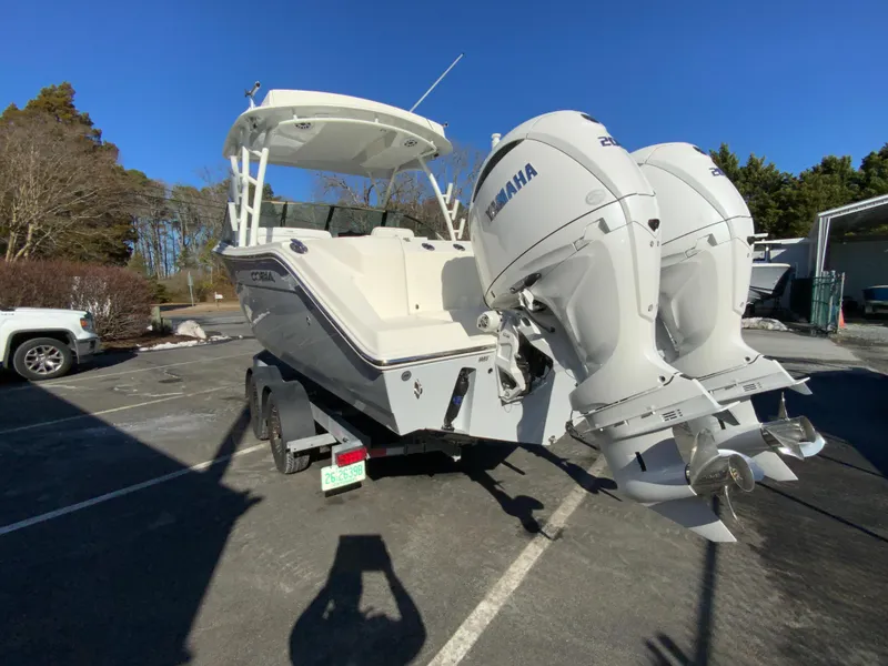 Slide: The Image of 2025 Cobia 280 Dual Console boat with twin Yamaha engines on a trailer. - 9