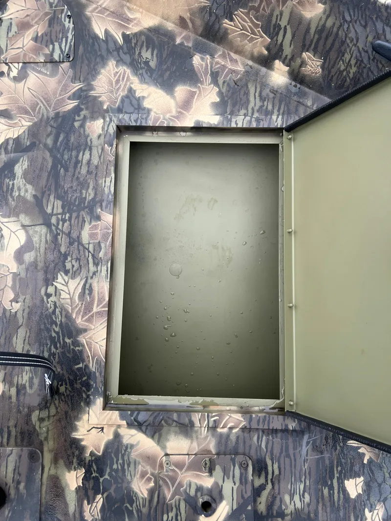Slide: The Image of 2024 Lund 1870 Predator SC boat storage compartment with camo pattern. - 11