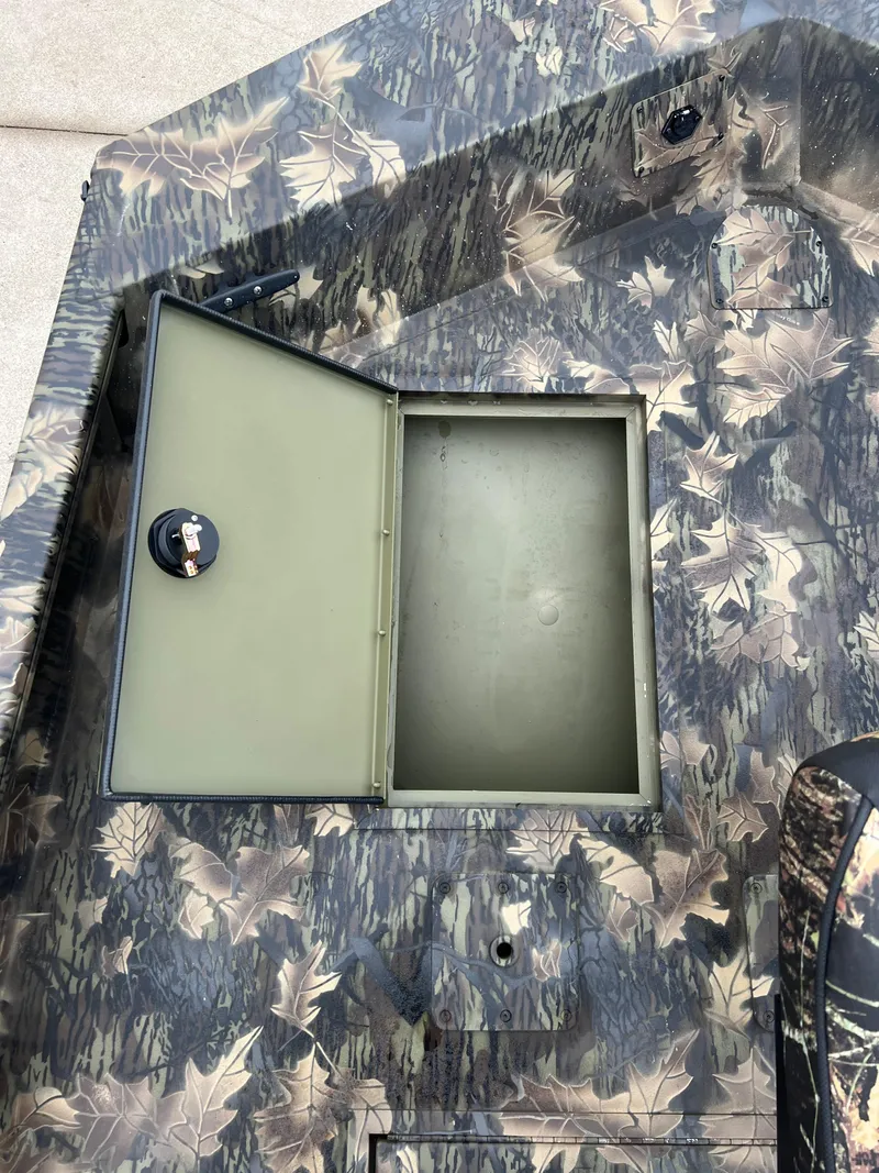 Slide: The Image of 2024 Lund 1870 Predator SC boat with open storage compartment, camo pattern. - 12