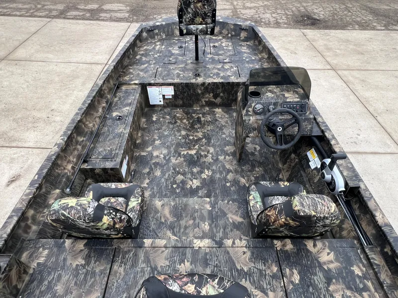 Slide: The Image of 2024 Lund 1870 Predator SC boat interior with camouflage seats and steering console. - 19
