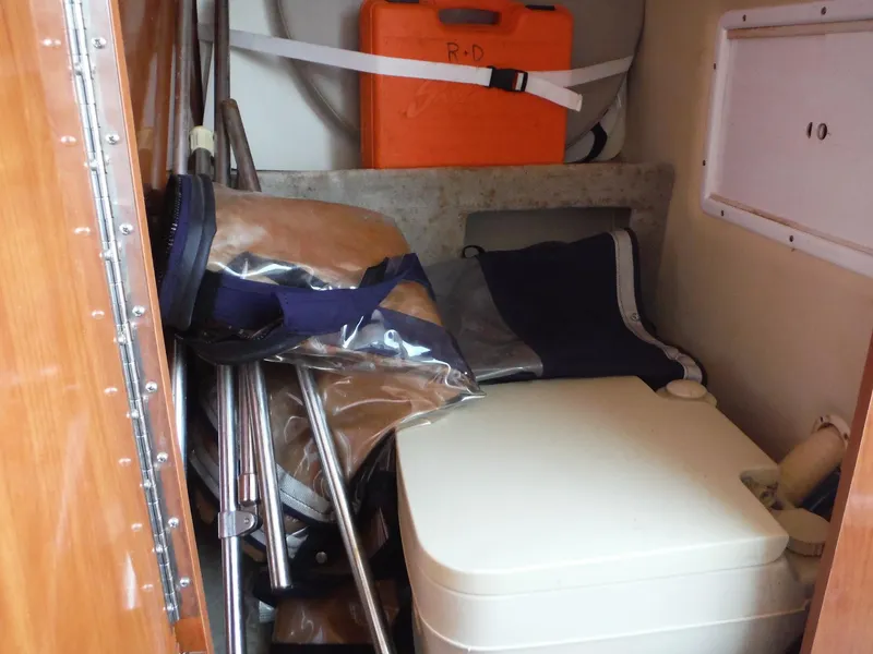 Slide: The Image of 2006 Four Winns 255 Sundowner cabin storage area with portable toilet and equipment. - 14