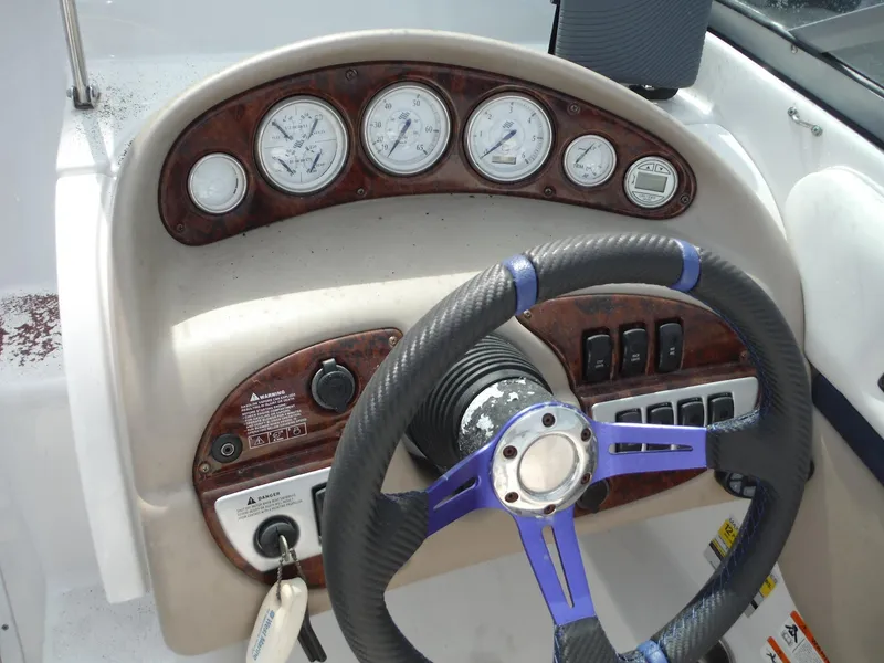 Slide: The Image of 2006 Four Winns 255 Sundowner boat dashboard with gauges and steering wheel. - 18