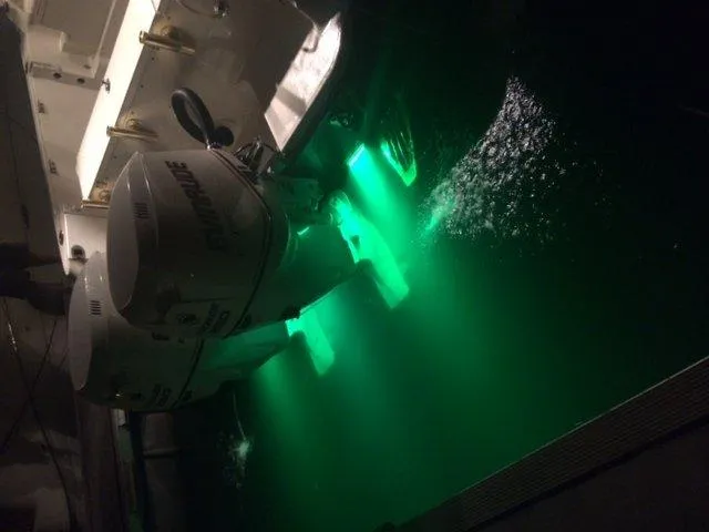 Slide: The Image of 2007 Hydra-Sports 2900VX boat with illuminated Evinrude outboard motors at night. - 24