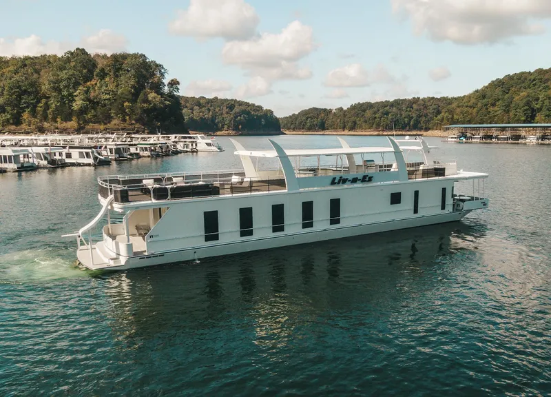 Slide: The Image of 2007 Sharpe 20 x 100 houseboat cruising on a scenic lake with forested hills. - 11