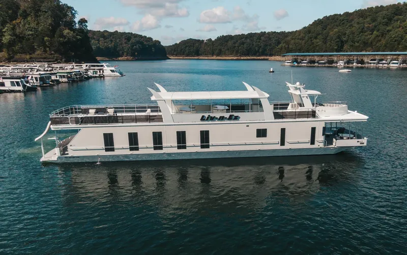 Slide: The Image of Sharpe 20 x 100 houseboat, 2007 model, cruising on a scenic lake with forested hills. - 13