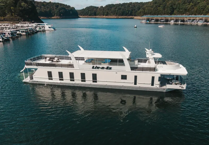 Slide: The Image of 2007 Sharpe 20 x 100 houseboat on a serene lake with forested shoreline. - 14