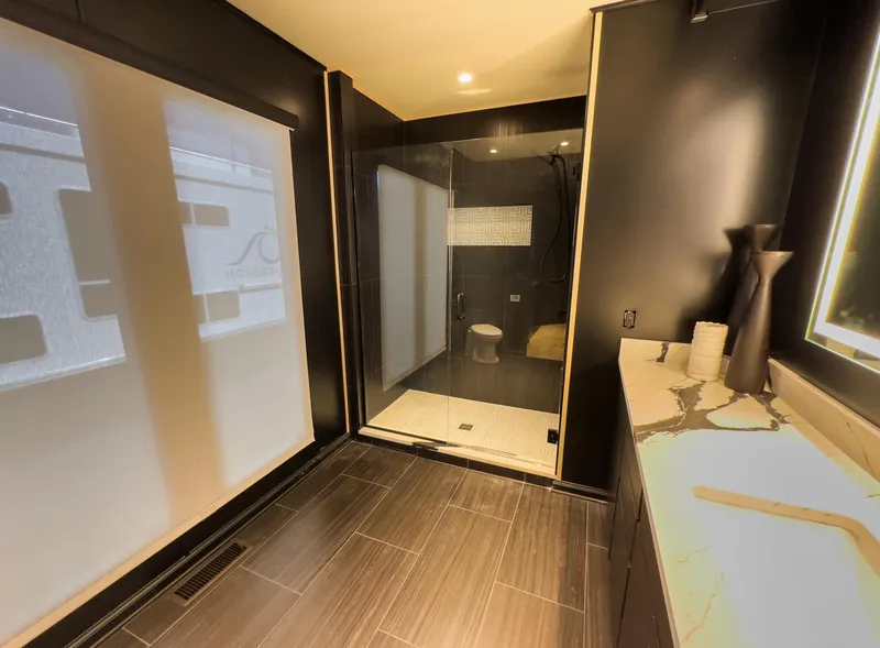 Slide: The Image of Modern bathroom with glass shower, dark tiles, and sleek fixtures, Sharpe 20 x 100, 2007 model. - 25