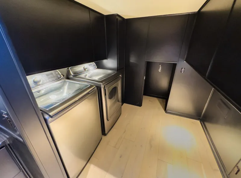Slide: The Image of Modern laundry room with Sharpe 20 x 100 washer and dryer, black cabinets, and light wood flooring. - 30