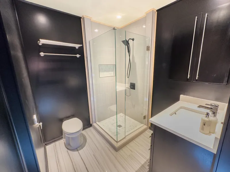 Slide: The Image of Modern bathroom with glass shower, black walls, and white fixtures. - 33
