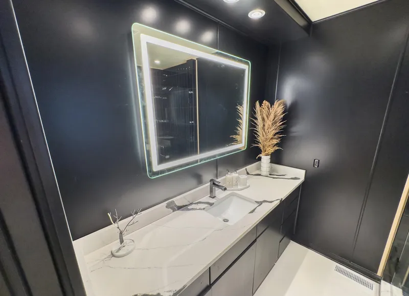Slide: The Image of Modern bathroom with illuminated mirror, sleek black walls, and white marble countertop. - 37