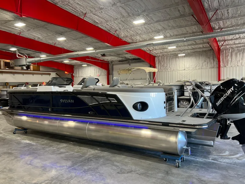 Slide: The Image of A 2024 Sylvan S-5 LZ DC pontoon boat in a warehouse. It features a Mercury outboard motor. - 3