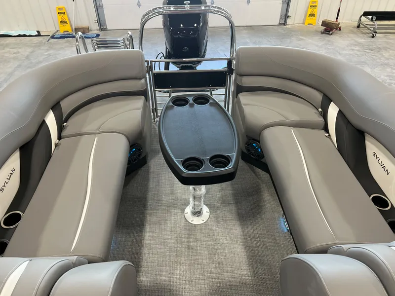 Slide: The Image of The image shows the interior of a Sylvan S-5 LZ DC boat with gray seating and a table. - 12