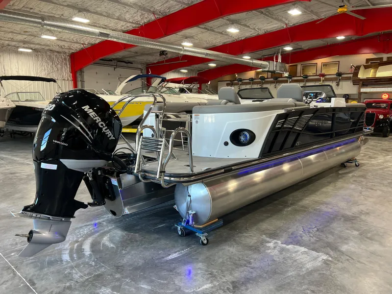 Slide: The Image of A 2024 Sylvan S-5 LZ DC pontoon boat is in a showroom. It features a Mercury outboard motor. - 7