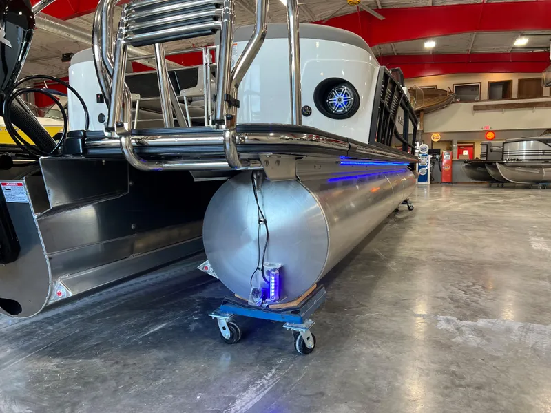 Slide: The Image of A 2024 Sylvan S-5 LZ DC pontoon boat is indoors. It features a modern design with blue LED lights. - 5