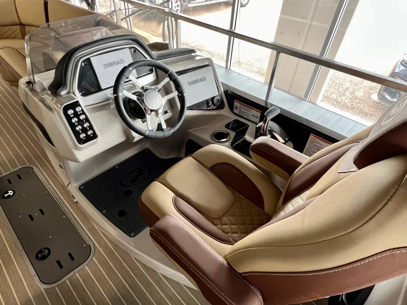Slide: The Image of 2024 Princecraft Vogue 25 XT boat cockpit with steering wheel and captain's chair. - 2