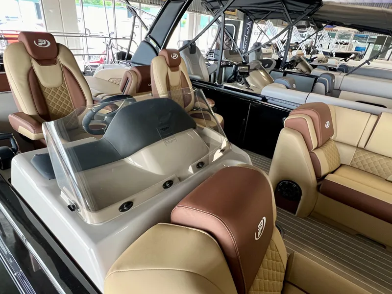 Slide: The Image of 2024 Princecraft Vogue 25 XT luxury pontoon boat interior with plush seating and modern helm. - 3