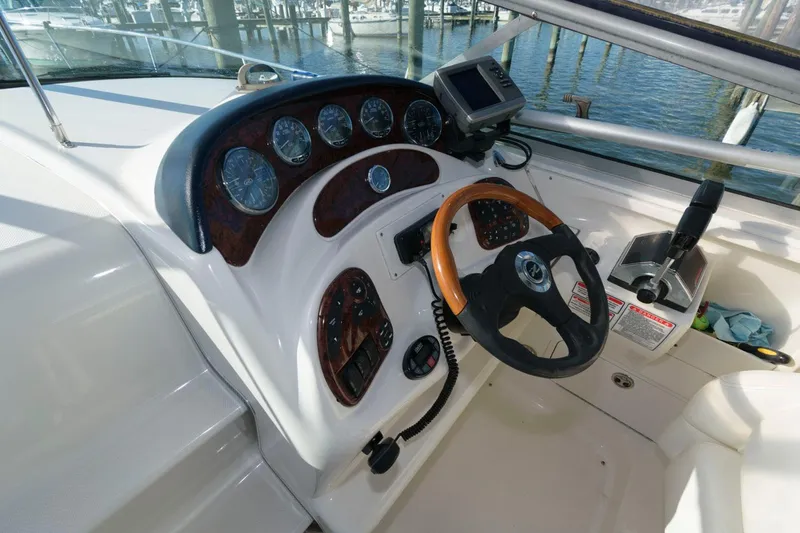 Slide: The Image of 2004 Sea Ray 280 Sundancer helm with wood-accented steering wheel and instrument panel. - 10